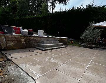 JPM Construction | Réalisation : Terrasse à Jodoigne avec chape, carrelage en pierre naturelle égyptienne, escalier pour jolie piscine et parement pierre naturelle 2