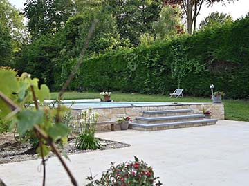 JPM Construction | Réalisation : Terrasse à Jodoigne avec chape, carrelage en pierre naturelle égyptienne, escalier pour jolie piscine et parement pierre naturelle 4